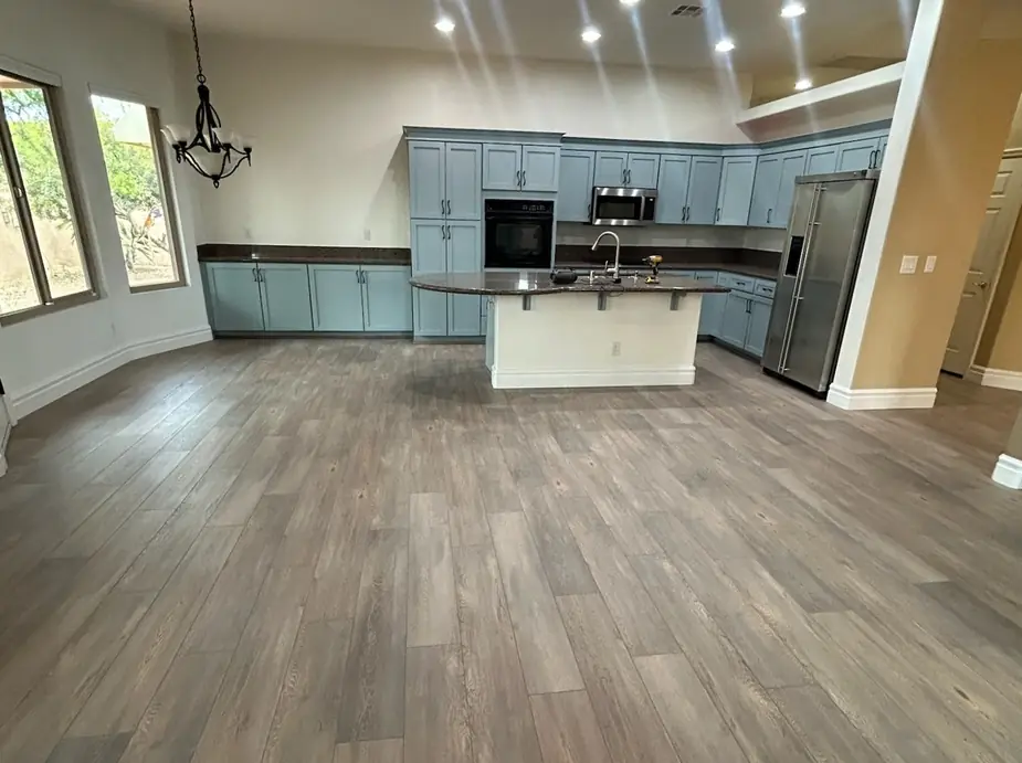Open kitchen and living room with grey wood-look plank flooring