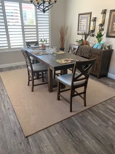Dining room with wood-look plank flooring and a jute rug