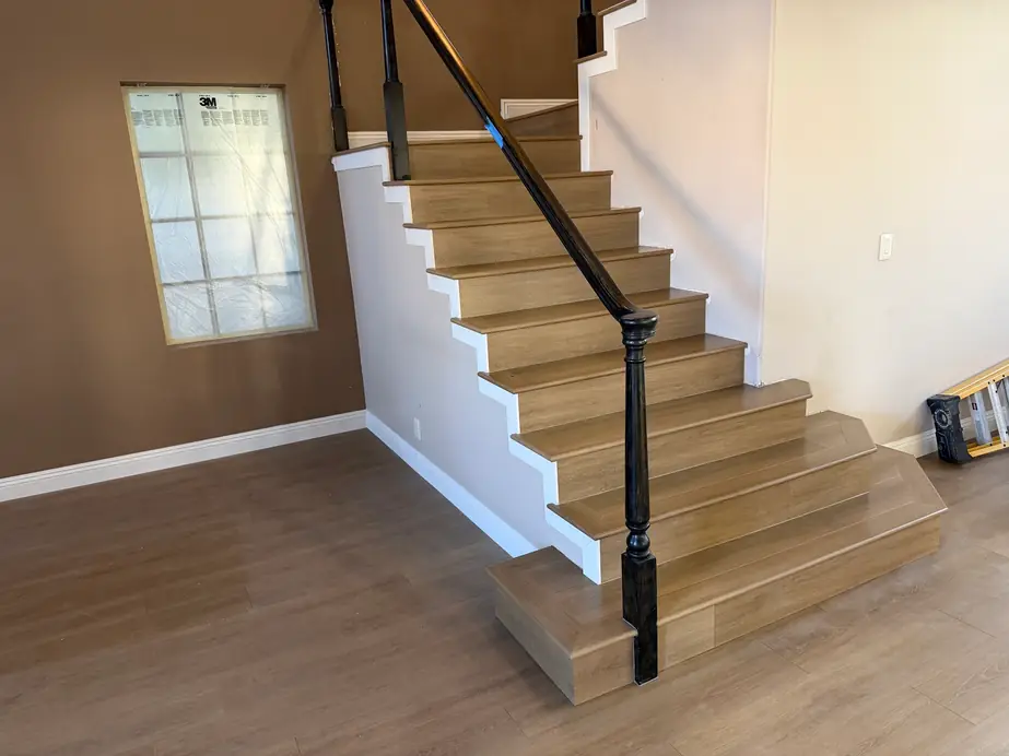 Wood-look plank treads on a Las Vegas staircase with black iron balusters