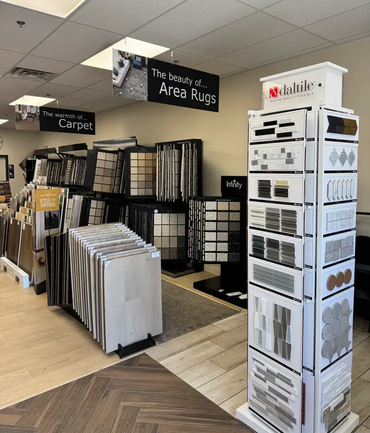 Inside the Affordable Flooring showroom on N Buffalo Dr: carpet racks, a Daltile display tower and a herringbone tile floor
