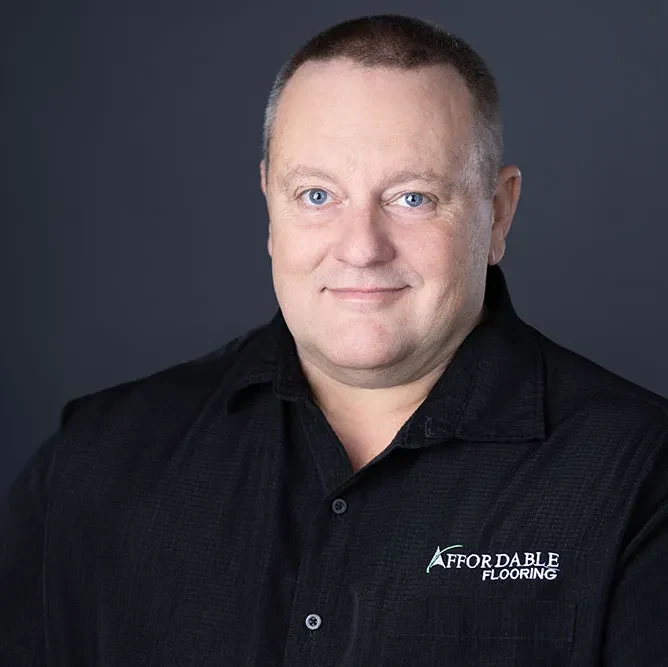 Mike Buchanan, Estimator at Affordable Flooring & More, in a company polo against a grey studio backdrop
